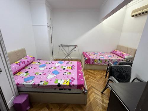 2 Betten in einem kleinen Zimmer mit rosa Bettwäsche in der Unterkunft Big apartment new furnished in Cairo downtown beside Nile river in Kairo