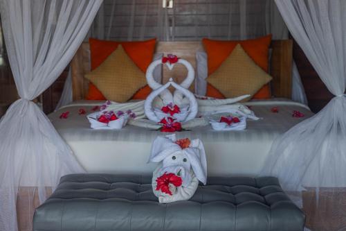 a bedroom with a bed with red flowers on it at Tatak Bunut Private Villa in Nusa Lembongan