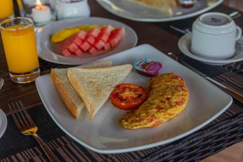 a plate of breakfast food with eggs and toast and fruit at Tatak Bunut Villa Ceningan in Nusa Lembongan
