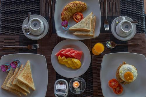a table with plates of breakfast food on it at Tatak Bunut Villa Ceningan in Nusa Lembongan