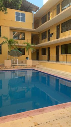 a large swimming pool in front of a building at HOTEL PALACIO in Acapulco