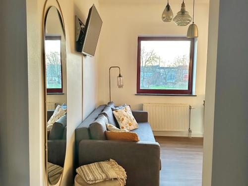 a living room with a couch and a mirror at Guesthouse De Wissen in Dilsen-Stokkem