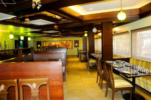 Hotel Ashray في اوجاين: غرفة طعام مع طاولات وكراسي في مطعم