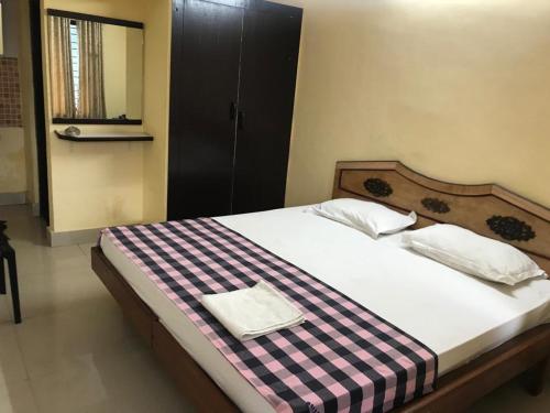 ein Schlafzimmer mit einem Bett mit einer karierten Decke darauf in der Unterkunft HOTEL LAKE VIEW in Manipala