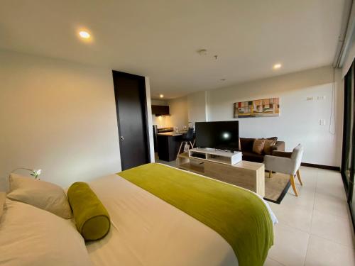 1 dormitorio con 1 cama grande y sala de estar en Room in Studio - Suite hotelera - A 5 minutos del Aeropuerto, en San Antonio de Pereira