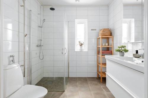 a bathroom with a shower and a toilet and a sink at Holiday home in Växjö