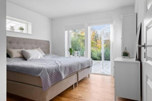a white bedroom with a bed and a window at Holiday home in Växjö