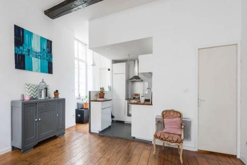 een keuken met een tafel en een stoel in een kamer bij Appartement XVIIIème centre historique in Bordeaux