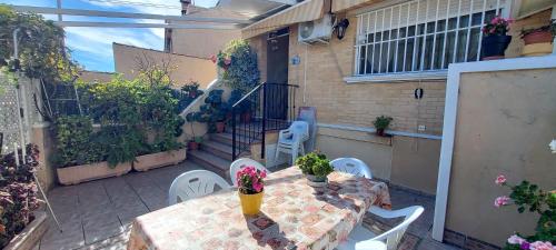 a patio with a table and chairs and some plants at Villa Adelina en Santa Pola in Santa Pola