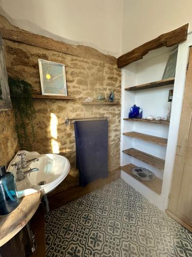 a bathroom with a sink and a counter and a shelf at Reynolds House in Faringdon