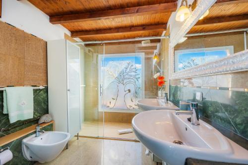 サンタ・マルガリーダにあるCas guixerのバスルーム(洗面台3台、大きな窓付)