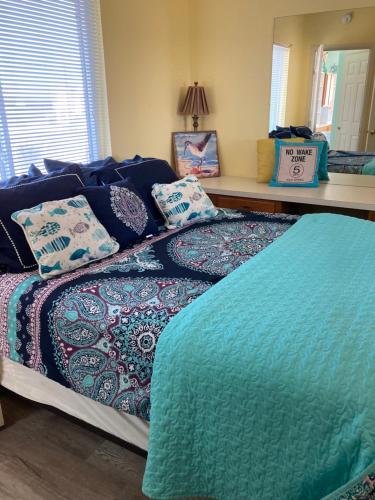 ein Bett mit Kissen darauf im Schlafzimmer in der Unterkunft Corpus Christi-Padre Island condo is walking distance to beach by Mustang Island, Sleeps Four, 2024 Traveler Award in Padre Island