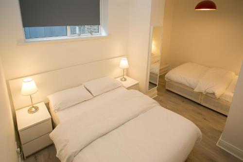 a bedroom with a white bed and two lamps at Temple Bar Essex Apartments in Dublin