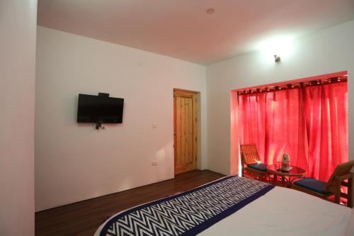 a bedroom with a bed and a television on a wall at Hotel Lhalingkha in Leh
