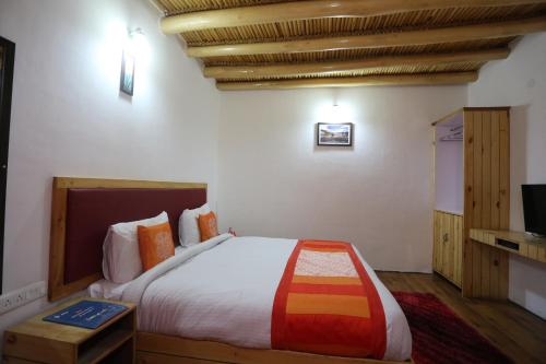 a bedroom with a large bed and a tv at Hotel Lhalingkha in Leh
