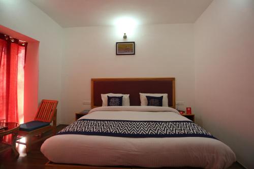 a bedroom with a bed and a light on the wall at Hotel Lhalingkha in Leh