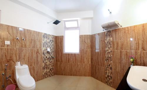a bathroom with a toilet and a sink at Hotel Lhalingkha in Leh