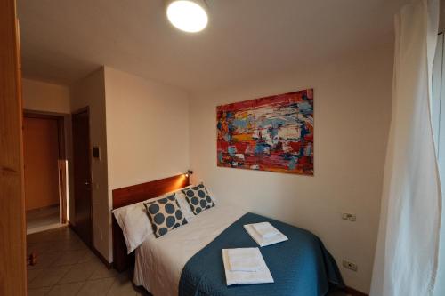 a bedroom with a bed and a painting on the wall at Locanda Milano 1873 in Brunate