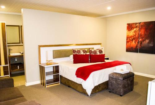 a bedroom with a large bed with red pillows at The Hank Bethlehem Pty Ltd in Bethlehem