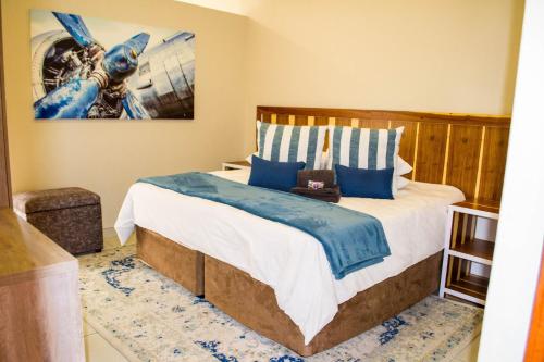 a bedroom with a king sized bed with blue pillows at The Hank Bethlehem Pty Ltd in Bethlehem