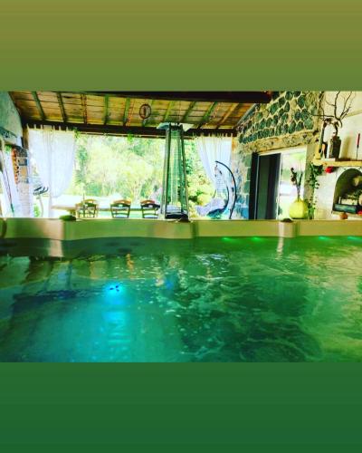 - une piscine dans une maison avec une grande fenêtre dans l'établissement Cottage River & Spa, à Saint-Ilpize