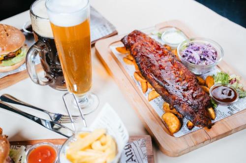 a table with a tray of food and a glass of beer at Podu' cu Lanturi in Bacău