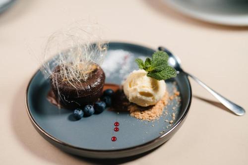 a plate with chocolate cupcakes and blueberries on a table at Podu' cu Lanturi in Bacău