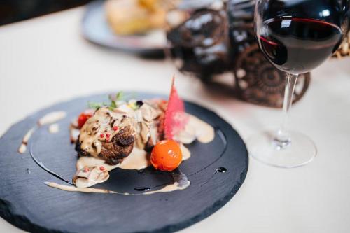 a plate of food on a table with a glass of wine at Podu' cu Lanturi in Bacău