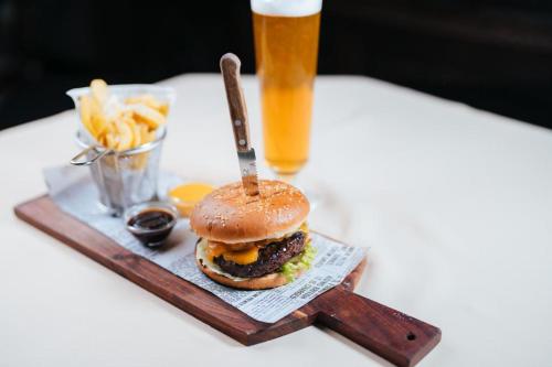 a hamburger and french fries on a table with a drink at Podu' cu Lanturi in Bacău