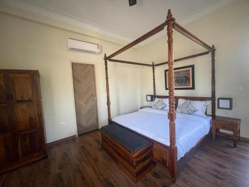 a bedroom with a four poster bed with white sheets at Tiger Retreat in Sawāi Mādhopur
