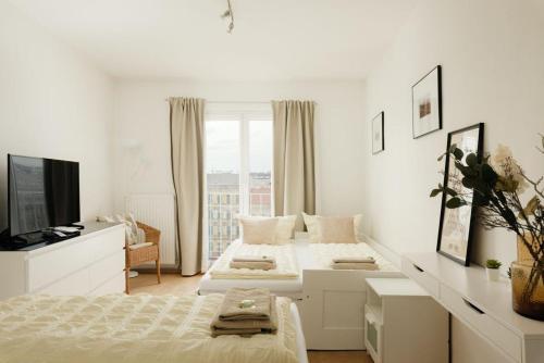 Cette chambre blanche comprend deux lits et une télévision. dans l'établissement Apartment ZENTRAL direkt an U-BAHN STATION, à Vienne