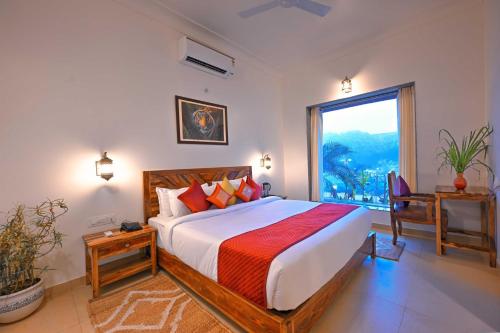 a bedroom with a large bed and a large window at Aranya Vilas, Ranthambhore in Khilchipur