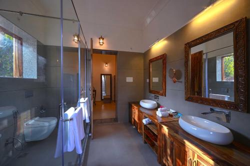 ein Badezimmer mit 2 Waschbecken und einem Spiegel in der Unterkunft Aranya Vilas, Ranthambhore in Khilchīpur