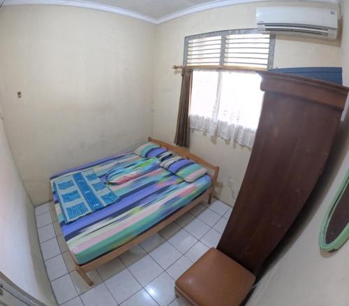 a small bedroom with a bed and a window at Omah Tegalrejo Family Only in Jetis