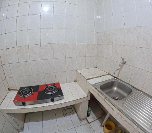a small kitchen with a stove and a sink at Omah Tegalrejo Family Only in Jetis