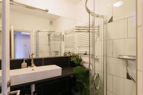 a bathroom with a sink and a mirror at Modern Vienna Apartment in Prime Location in Vienna