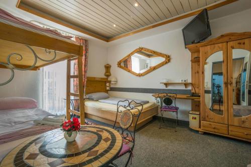 Schlafzimmer mit einem Bett, einem Tisch und einem Spiegel in der Unterkunft Hotel & Restaurant Elbschetal in Wetter
