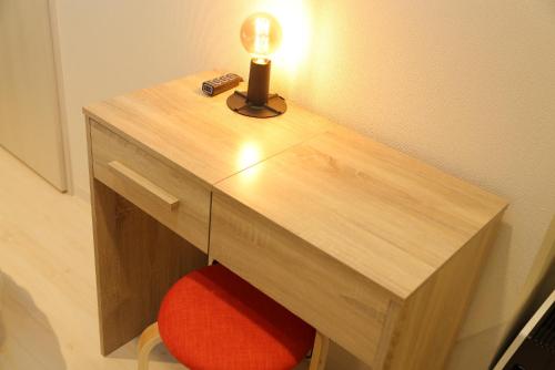 a wooden desk with a lamp and a red chair at Tokyo Time Traveler 駅徒歩5分 暮らすように泊まれるホテル in Tokyo