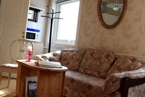 a living room with a couch and a table with a mirror at Mysig Lägenhet -Ralph Lundstengården in Luleå