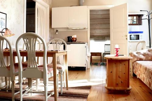 cocina y sala de estar con mesa y sillas en Mysig Lägenhet -Ralph Lundstengården en Luleå