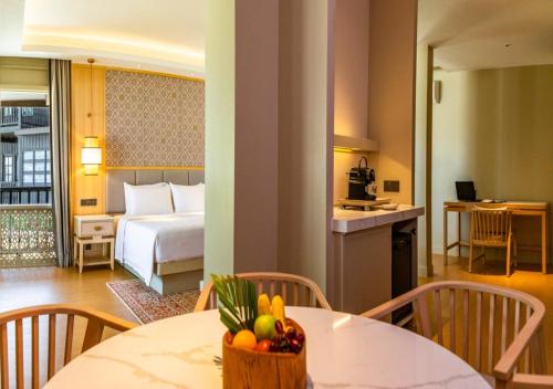a hotel room with a bed and a table with a bowl of fruit at Pelangi Beach Resort & Spa, Langkawi in Pantai Cenang