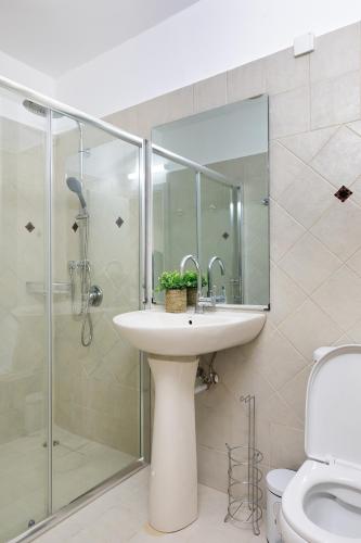 a bathroom with a sink and a glass shower at By Eezy- דירה משפחתית מפנקת 3 חדרי שינה - Hanechoshet in Eilat