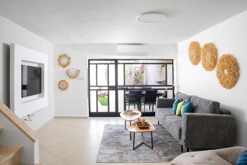a living room with a couch and a table at By Eezy- דירה משפחתית מפנקת 3 חדרי שינה - Hanechoshet in Eilat