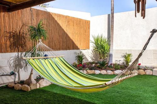 a hammock in a patio with a garden at By Eezy- דירה משפחתית מפנקת 3 חדרי שינה - Hanechoshet in Eilat