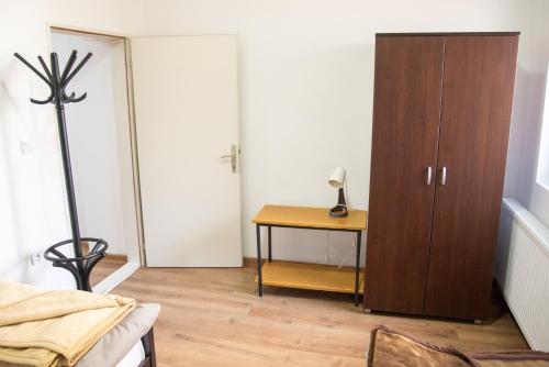 a bedroom with a wooden cabinet and a table at Apartments Kuca Aleksic in Niš