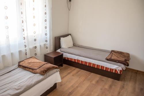 a small room with two beds and a window at Apartments Kuca Aleksic in Niš