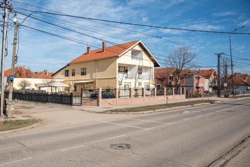 a white house with a red roof on a street at Apartments Kuca Aleksic in Niš