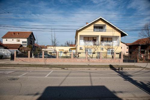 a house with a fence in front of a street at Apartments Kuca Aleksic in Niš