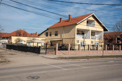 a house with a fence in front of a street at Apartments Kuca Aleksic in Niš