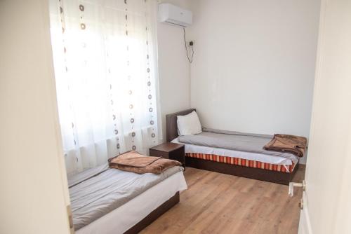 two beds in a room with a window at Apartments Kuca Aleksic in Niš